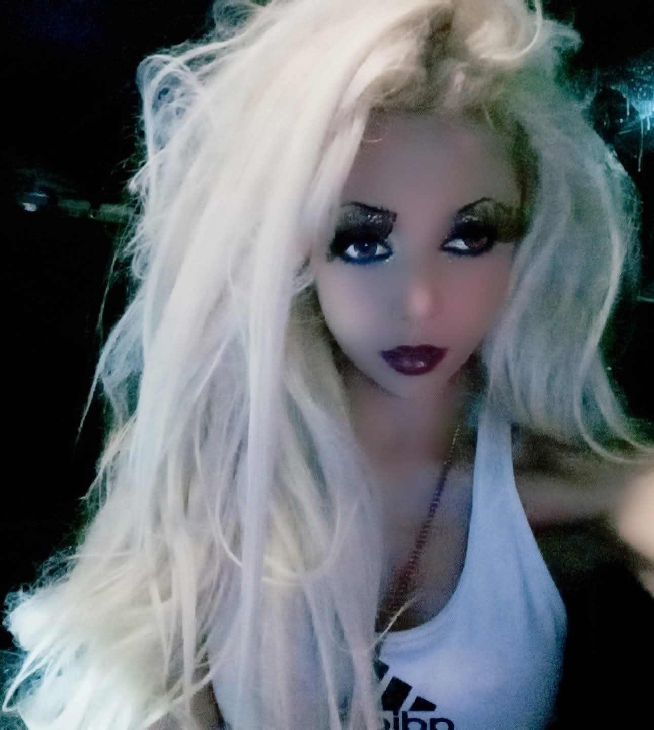 Jennifer Jorgensen Ahmed with long platinum blonde hair and dark berry lipstick, close-up portrait