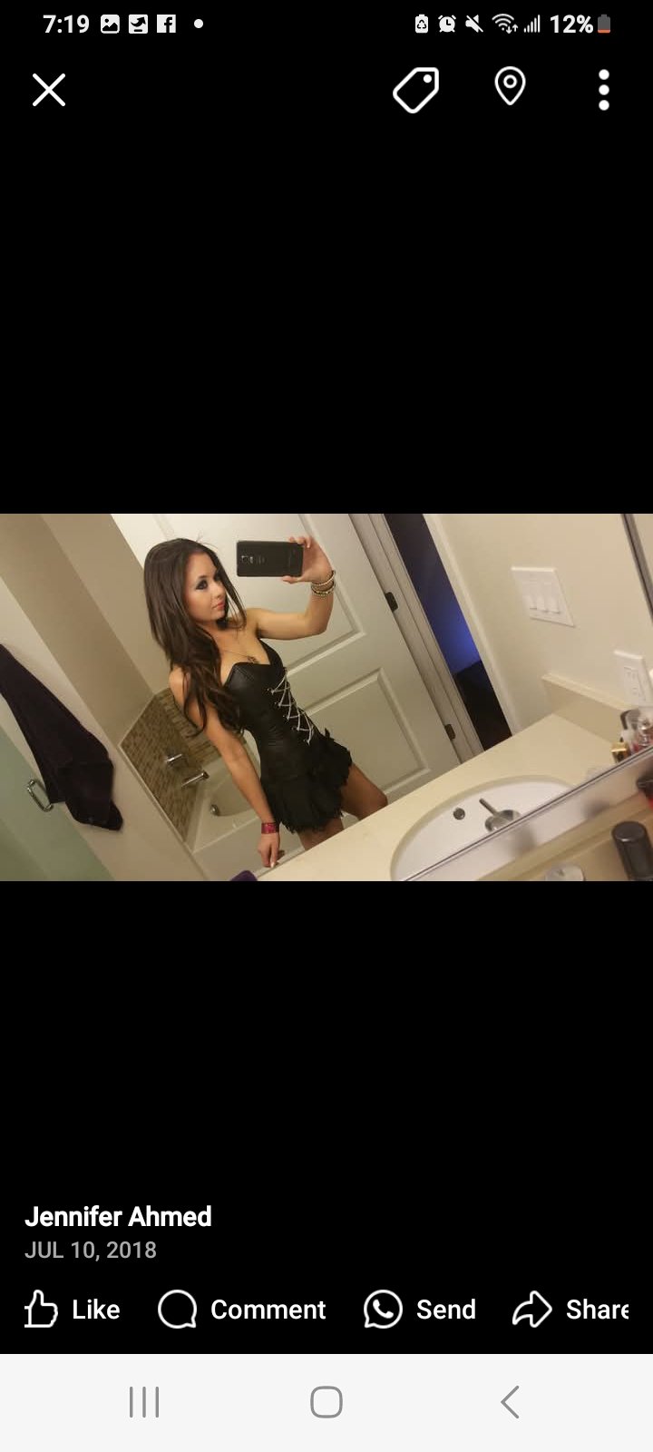 Jennifer Jorgensen Ahmed in a black corset dress taking a bathroom mirror selfie