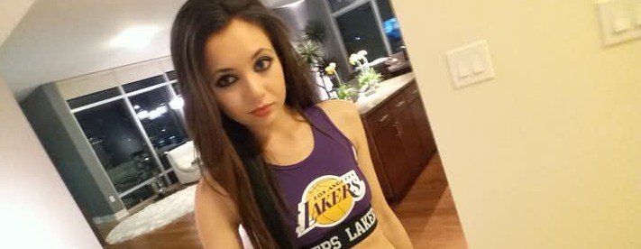 Jennifer Jorgensen Ahmed in a purple Lakers crop top taking a selfie at home
