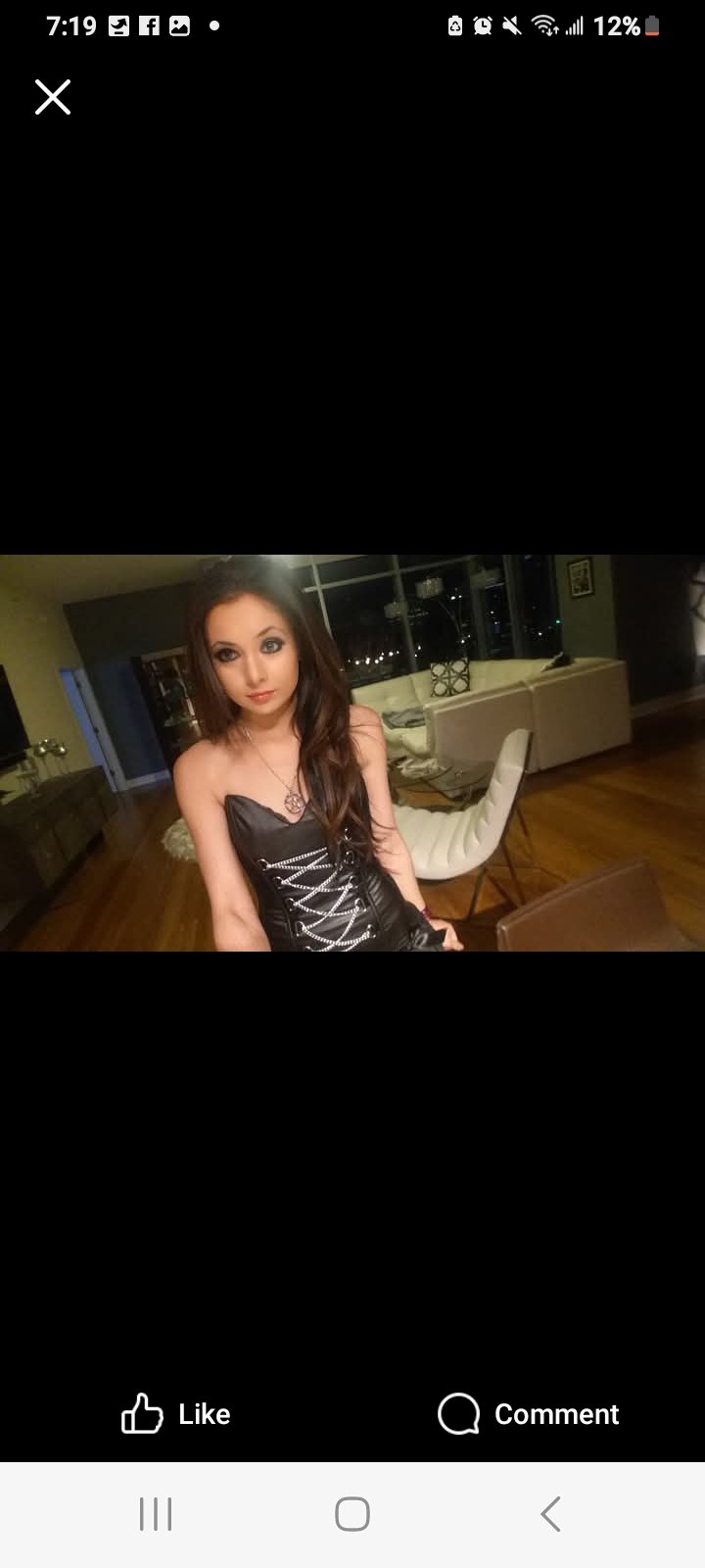 Jennifer Jorgensen Ahmed in a black lace-up corset dress in a high-rise living room